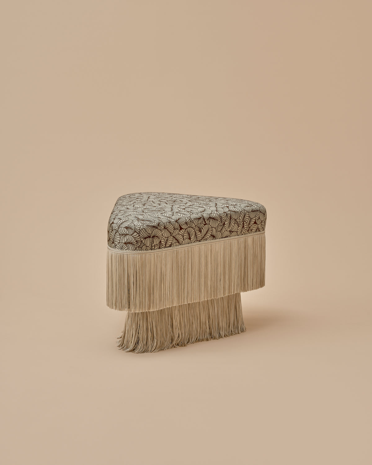 Nerova Ottoman by Love House x Spencer Malinski, three-quarter view of the softened triangle ottoman in Deco Fan Jacquard with sage ombre fringe, available at Love House New York