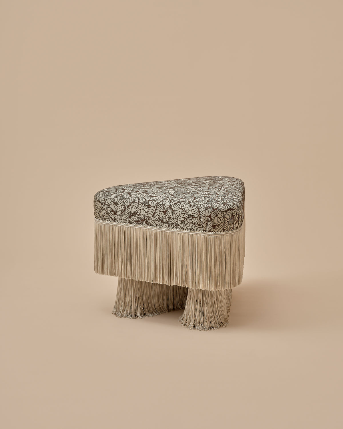 Nerova Ottoman by Love House x Spencer Malinski, angled view of the triangular seat and fringe-wrapped legs, available at Love House New York